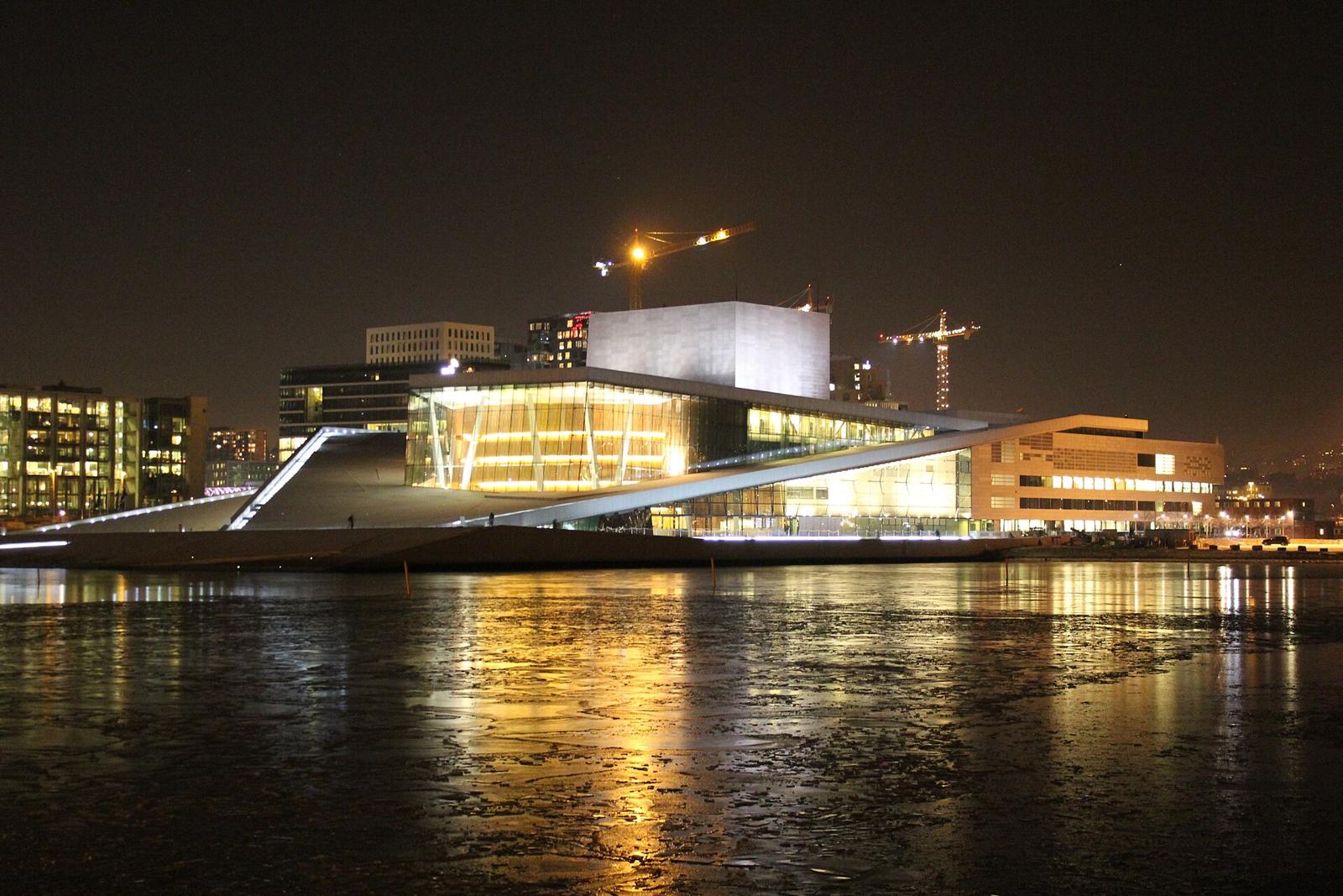 Oslo Opera House lit at night over the water