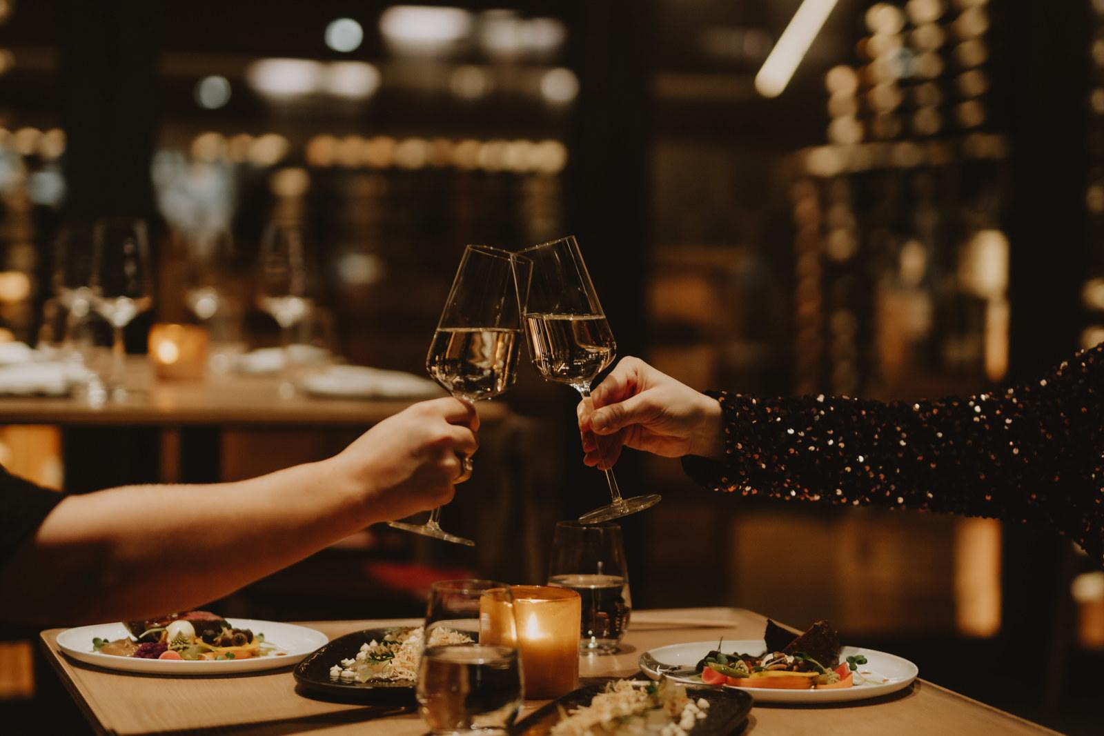Glasses raised over dinner by candlelight